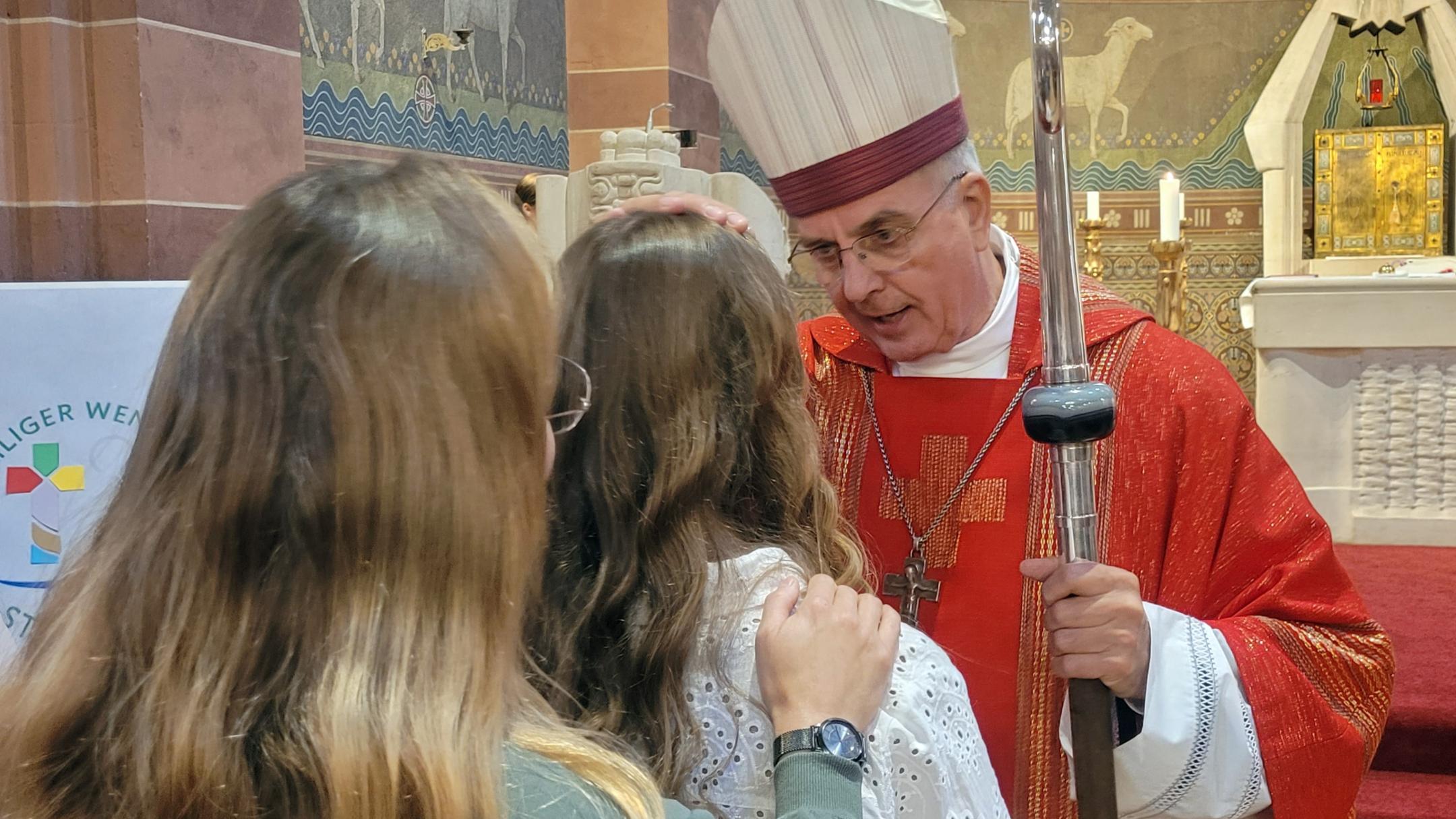Weihbischof Jörg Peters firmt eine Jugendliche in St. Remigius in Bliesen.