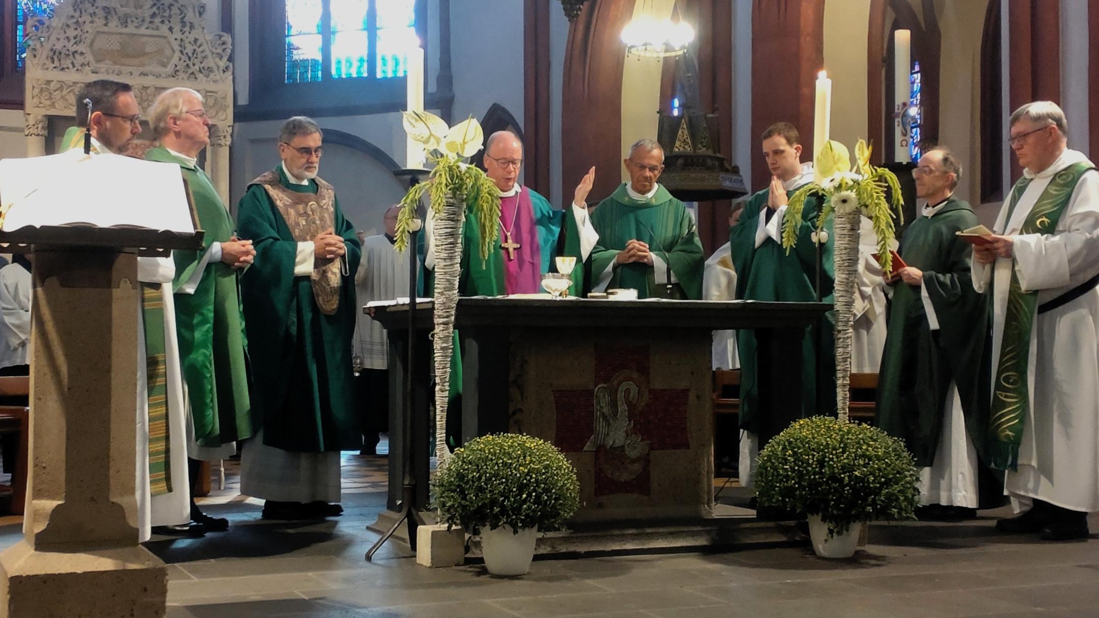 Geistliche stehen versammelt um einen Altar,