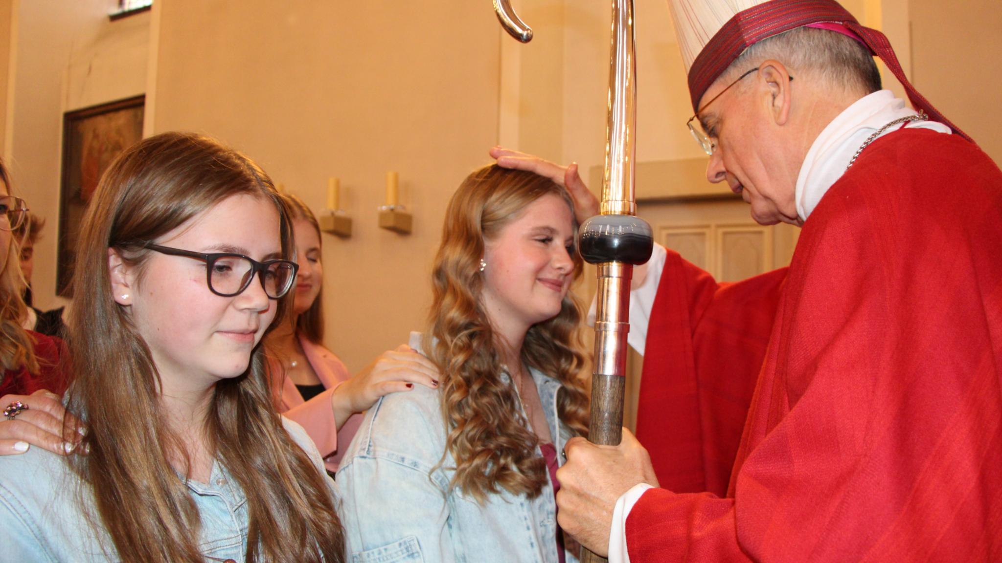 Weihbischof Peters spendet einer jungen Christin das Firmsakrament.