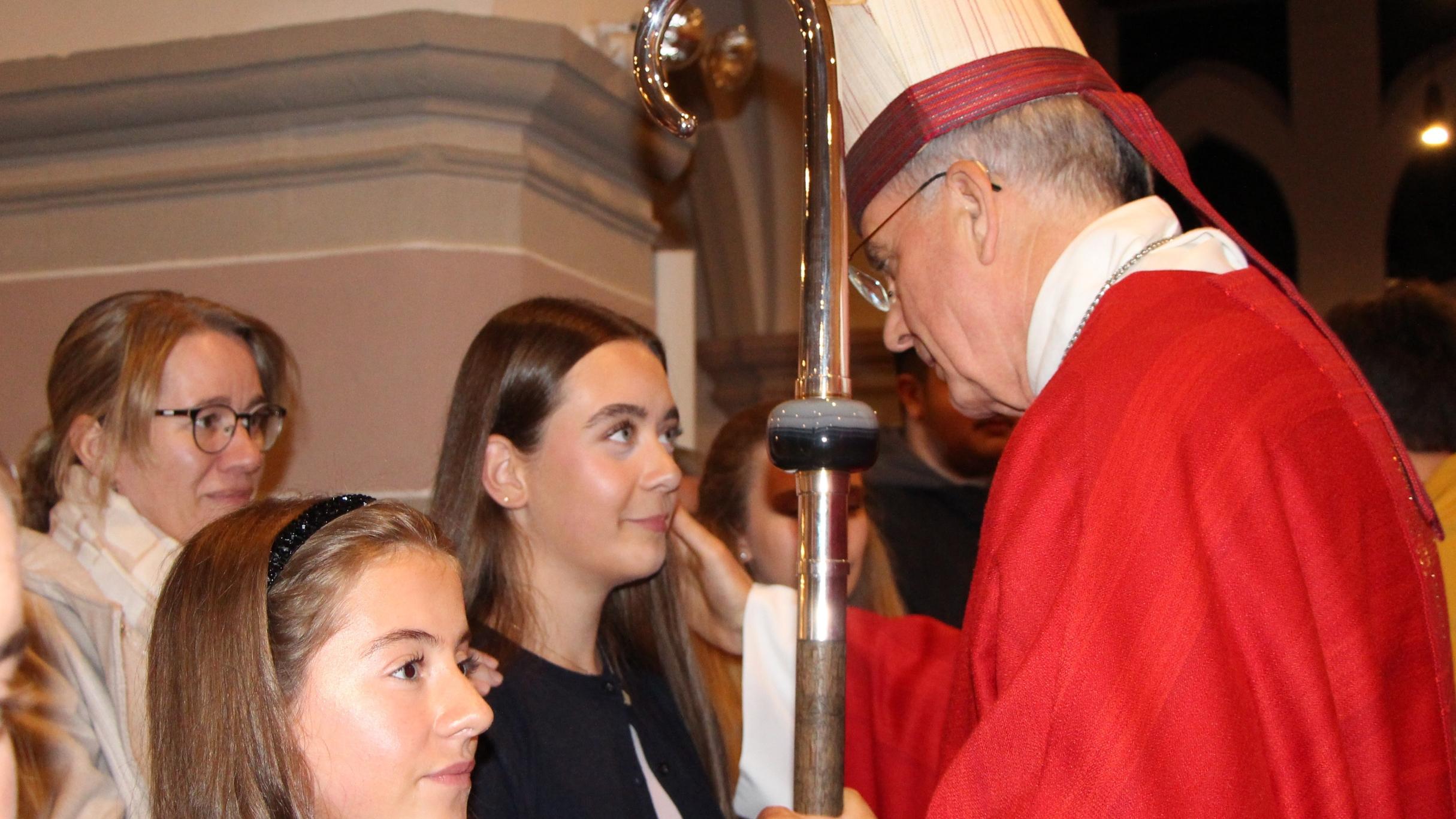 Weihbischof Peters spendet einer jungen Erwachsenen das Sakrament der Firmung